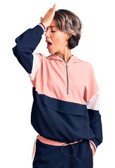 Young beautiful woman wearing sportswear surprised with hand on head for mistake, remember error. forgot, bad memory concept.