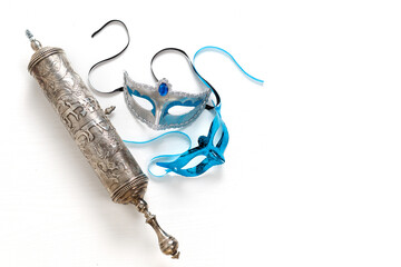 The Scroll of Esther (With an inscription in Hebrew "Book of Esther") and Purim Festival objects. On white background. Top view