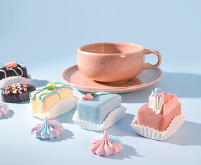 An Enchanting Espresso and Sweet Treat Experience: A Pink Mug and a Selection of Decorative and Delicious Desserts on a Pastel Blue Background