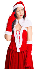 Young beautiful caucasian woman wearing santa claus costume shooting and killing oneself pointing hand and fingers to head like gun, suicide gesture.