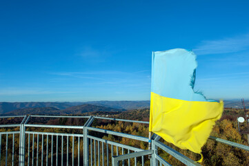 The flag of Ukraine on the observation tower high in the mountains above the Poloniny