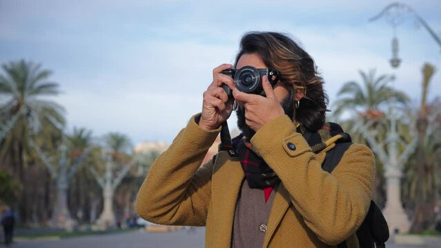 Tourist taking pictures of the monument in Barcelona with a camera on vacations. Young photographer enjoying doing photos in a weekend trip. Travel concept. Slow motion. High quality 4k footage