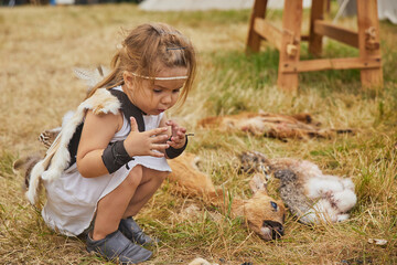 child at a Viking festival looking at animal skins in Denmark.