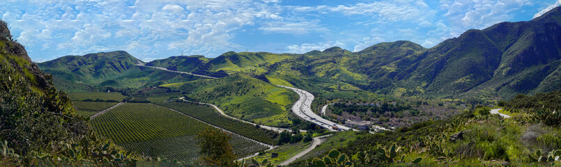 Aerial Panoramic 101 Ventura Highway in Southern California winding through green hills and valleys...