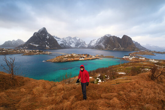 An Asian Tourist Traveling On White Snow Mountain In Lofoten Islands, Nordland County, Norway, Europe. Hills, Nature Landscape In Winter Season. Winter Background. People Lifestyle In Vacation Holiday