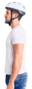 Young handsome man wearing bike helmet looking to side, relax profile pose with natural face with confident smile.