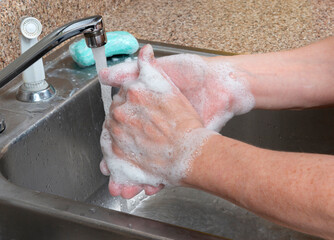 Fototapeta premium Woman Washing Hands With Bar Soap In Kitchen Sink