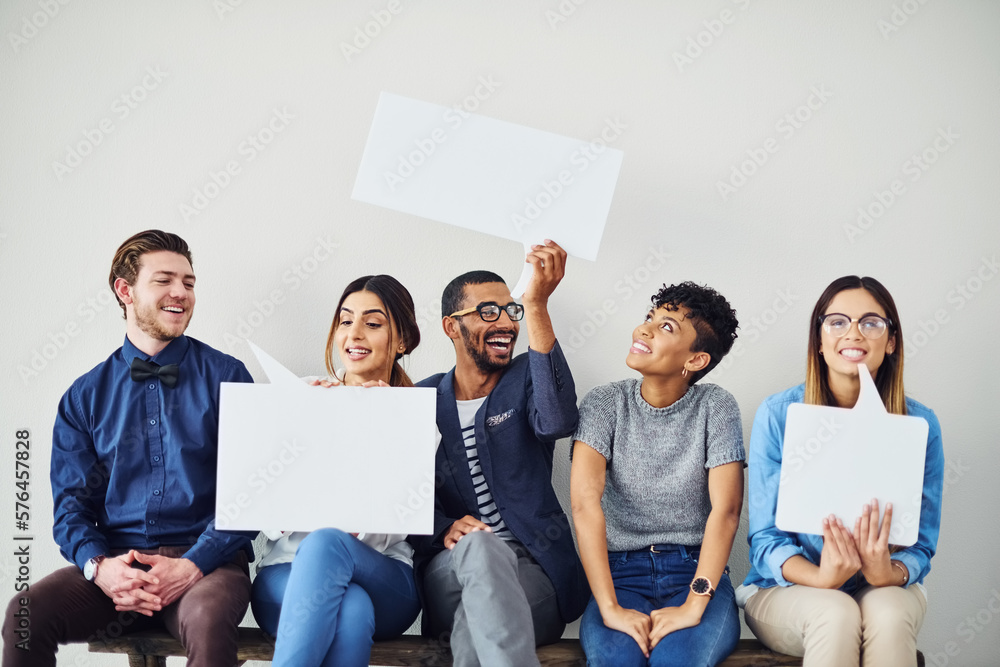 Poster lets put whats on our minds on a message. shot of a diverse group of creative employees holding up s