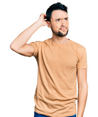 Hispanic man with beard wearing casual t shirt confuse and wondering about question. uncertain with...