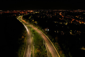 Fototapeta na wymiar Top down view to road. Romantic night aerial photo of cars traveling. The light on the road at night in city. Background scenic road drone view. Tram railways background