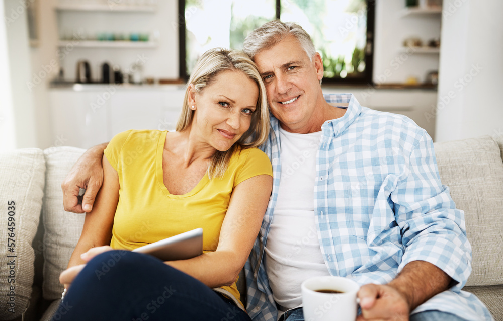 Poster living our happily ever after side by side. cropped shot of a mature couple using a digital tablet w
