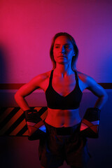 Fototapeta na wymiar Boxer woman with boxing gloves illuminated with neon lights.