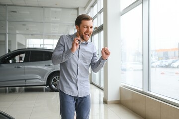 Fototapeta premium a man chooses a new car for himself walks between the rows in a car dealership
