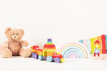 Educational kids toys collection. Teddy bear, wood train, rainbow, wooden educational baby toys on white background. Sustainable, eco-friendly toys. Front view