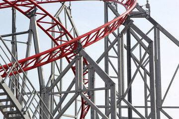 Metal roller coaster close up with red rails