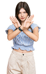 Young beautiful caucasian girl wearing casual clothes rejection expression crossing arms doing negative sign, angry face
