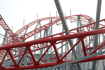 Metal roller coaster close up with red rails