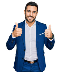 Young hispanic man wearing business jacket success sign doing positive gesture with hand, thumbs up...