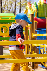 todler boy at the playground on a sunny spring day with space for text