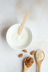 Composition of almonds and sesame seeds in wooden spoons. The concept of proper nutrition, healthy lifestyle, healthy fats and oils. 