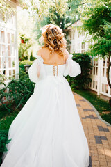 Fototapeta premium rear view. the bride walks through the garden. 