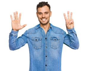 Young hispanic man wearing casual denim jacket showing and pointing up with fingers number eight while smiling confident and happy.