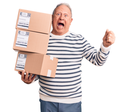 Senior handsome grey-haired man holding delivery boxes screaming proud, celebrating victory and success very excited with raised arms