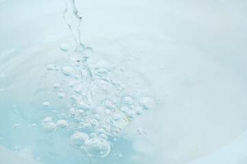 a jet of water pours into a container of water. 