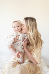 mother and baby daughter with floral dress and bonnet