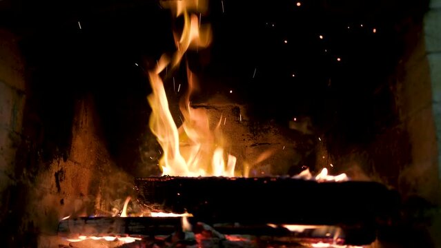 add tossing logs in fire burning flames close-up in the fireplace flames heat heat to warm up heat no electricity ancient house of life around the fire cook food on the fire