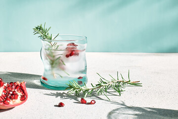 Pomegranate gin fizz cocktail with sparkling wine, rosemary and ice. Holidays refreshing alcoholic drink. Pomegranate cold detox beverage. - obrazy, fototapety, plakaty