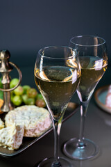 Glasses of sparkling white wine champagne or cava with bubbles and french soft cheese on background