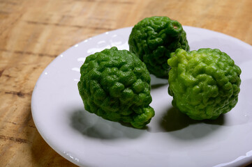 Citrus hystrix, kaffir lime or makrut lime, citrus fruit native to tropical Asia. Fruit and leaves used in Southeast Asian cuisine, essential oil is used in perfumery for intense citrus fragrance.