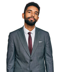 Young african american man wearing business clothes relaxed with serious expression on face. simple...