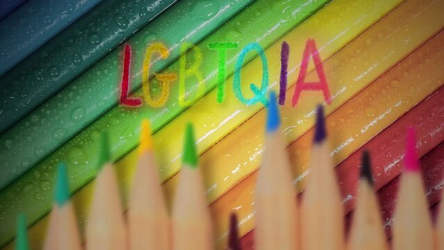 Color Crayons LGBTQIA Word Rainbow Multicolored Background. LGBTQIA word written over some colorful crayons. Multicolored motion background