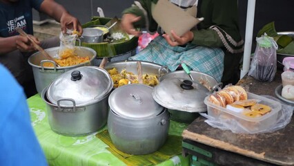 Nasi liwet seller preparing customer order. Selling liwet rice. Nasi Liwet Solo. Traditional rice dish from Solo; savory steamed rice with pulled chicken curry, coconut gravy
