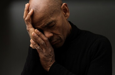 praying to god with hands together Caribbean man praying with black background stock photos stock photo