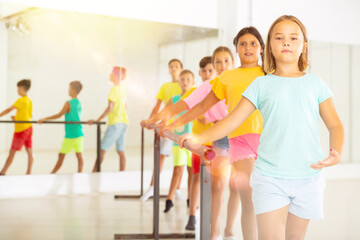 Children exercising ballet moves during their group training.