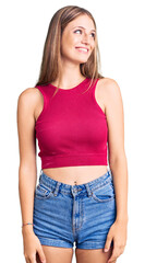 Fototapeta premium Young beautiful blonde woman wearing elegant summer shirt looking away to side with smile on face, natural expression. laughing confident.