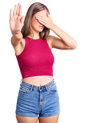 Young beautiful blonde woman wearing elegant summer shirt covering eyes with hands and doing stop gesture with sad and fear expression. embarrassed and negative concept.
