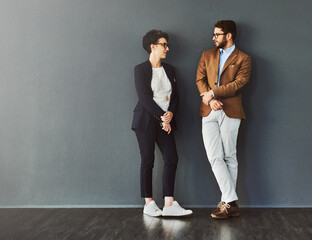 You can learn a lot from your colleagues. Shot of two designers having a conversation while leaning...