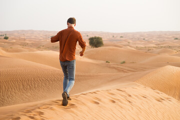 Man walking dunes at sunrise