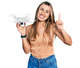 Hispanic young woman holding drone surprised with an idea or question pointing finger with happy face, number one