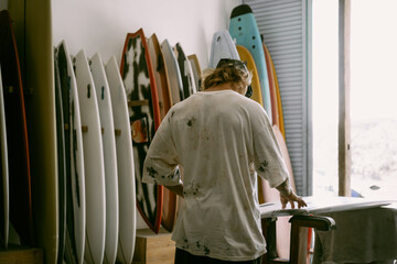 Man choosing a surfboard in a surfboard shop