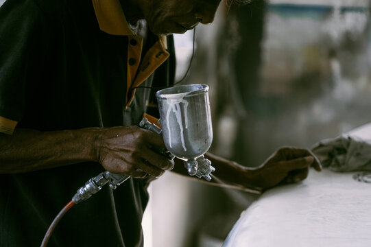 Man repairs surfboard, hands close up, Surfboard Workshop in Bali