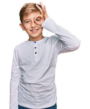 Little caucasian boy kid wearing casual clothes doing ok gesture with hand smiling, eye looking through fingers with happy face.