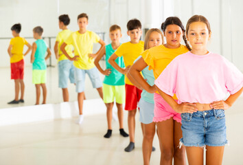 Obraz premium Group of kids standing in row during their dance training in studio.