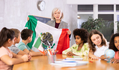 Fototapeta premium in geography lesson, students carefully listen to woman teacher who talks about Mexicо