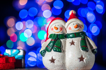 Christmas composition - Christmas tree toy two snowmen on a blue background with bokeh