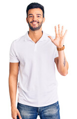Young handsome hispanic man wearing casual clothes showing and pointing up with fingers number five while smiling confident and happy.